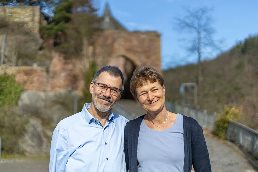 Die Gastgeber des Burghauses Heimbach Erich und Jana Schmidt stehen vor der Burg.