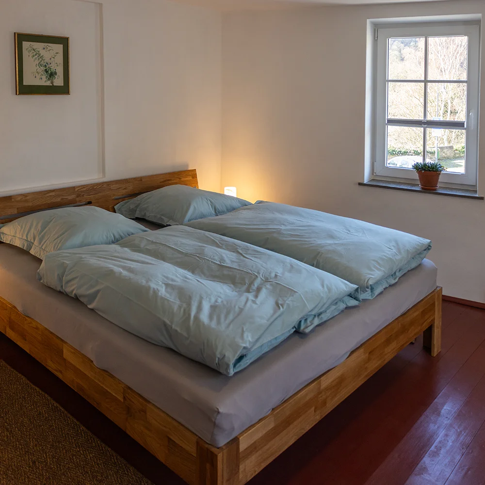Gemütliches Schlafzimmer mit Doppelbett und Blick auf die Burg Heimbach im Ferienhaus.